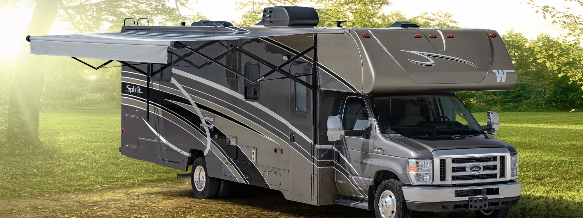 Winnebago Spirit in a sunny field with fully extened awning